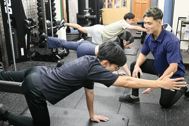トレーナーが会員の目線に合わせてトレーニングをサポートする様子